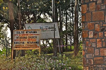 [Translate to Englisch:] Eingangsschild der Kirche und Gedenkstätte Ntarama mit Angabe der Opferzahlen (5000)