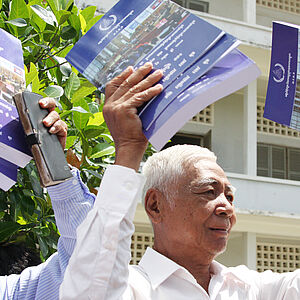 Chum Mey (l.) and Vann Nath with the judgment against former director of Prison S-21 